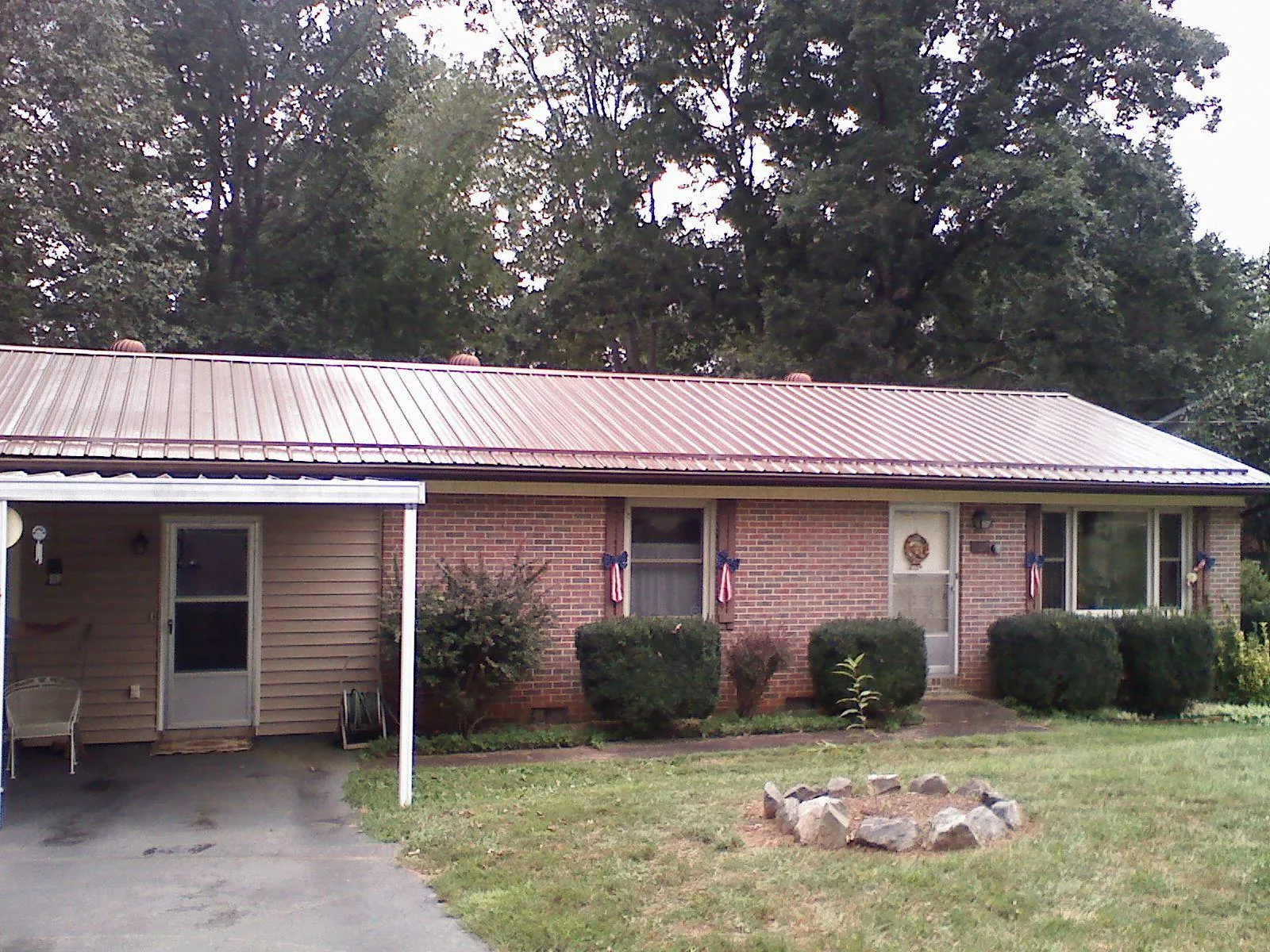 Bronze metal roof and carport on a brick ranch home — Roof Repair work by our crew in Anderson